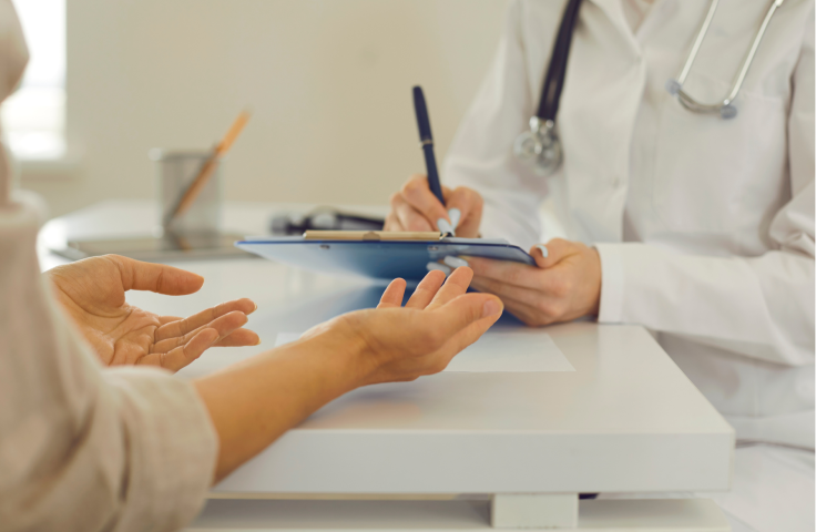 Doctor taking notes while meeting with a patient. Focus on note taking.